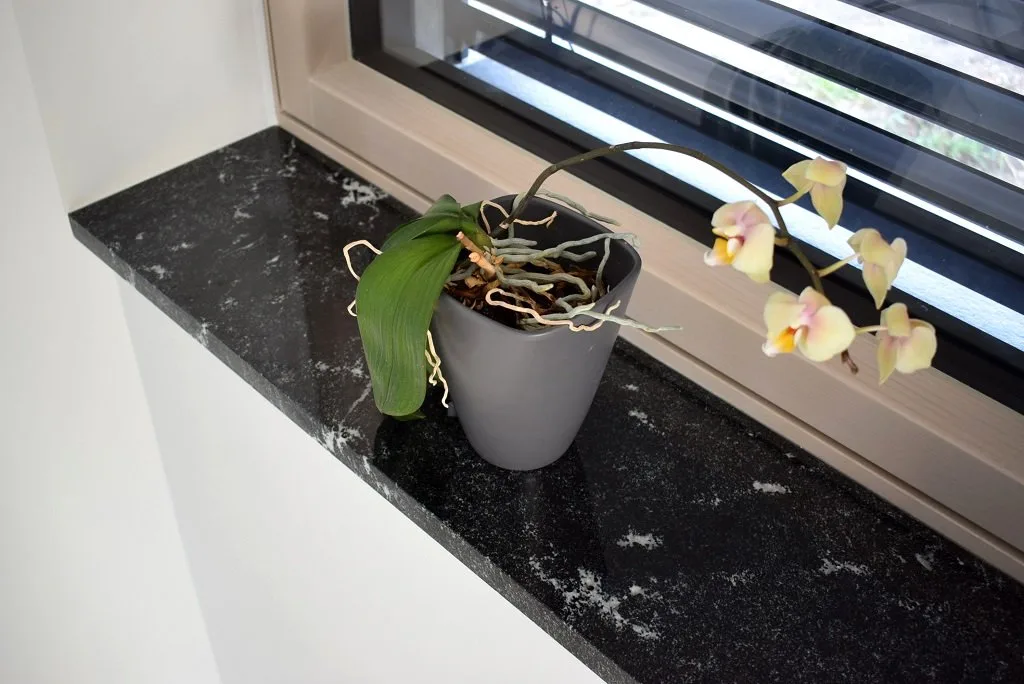 Kamenný vnitřní parapet ze žuly v béžovém odstínu s pokojovou rostlinou